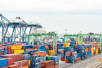 Ein Containerterminal mit verschiedenfarbigen Containern und Kränen