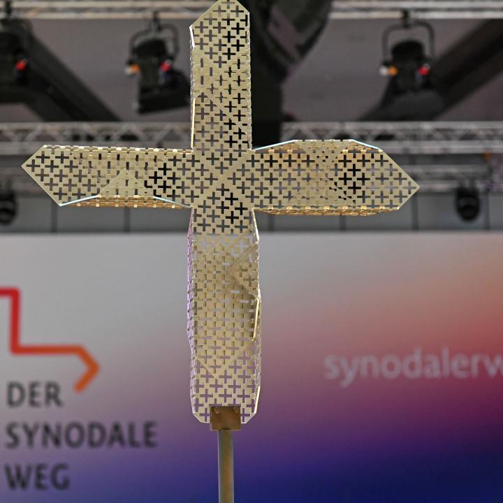 Kreuz vor einem Banner des Synodalen Wegs
