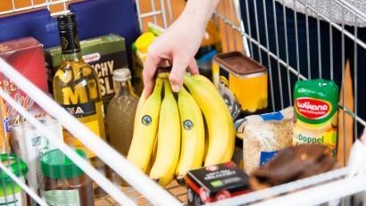 Ein Einkaufswagen voller Fairtrade-Produkte: Bananen, Wein, Müsli, Keksen, Marmelade und viel mehr. 